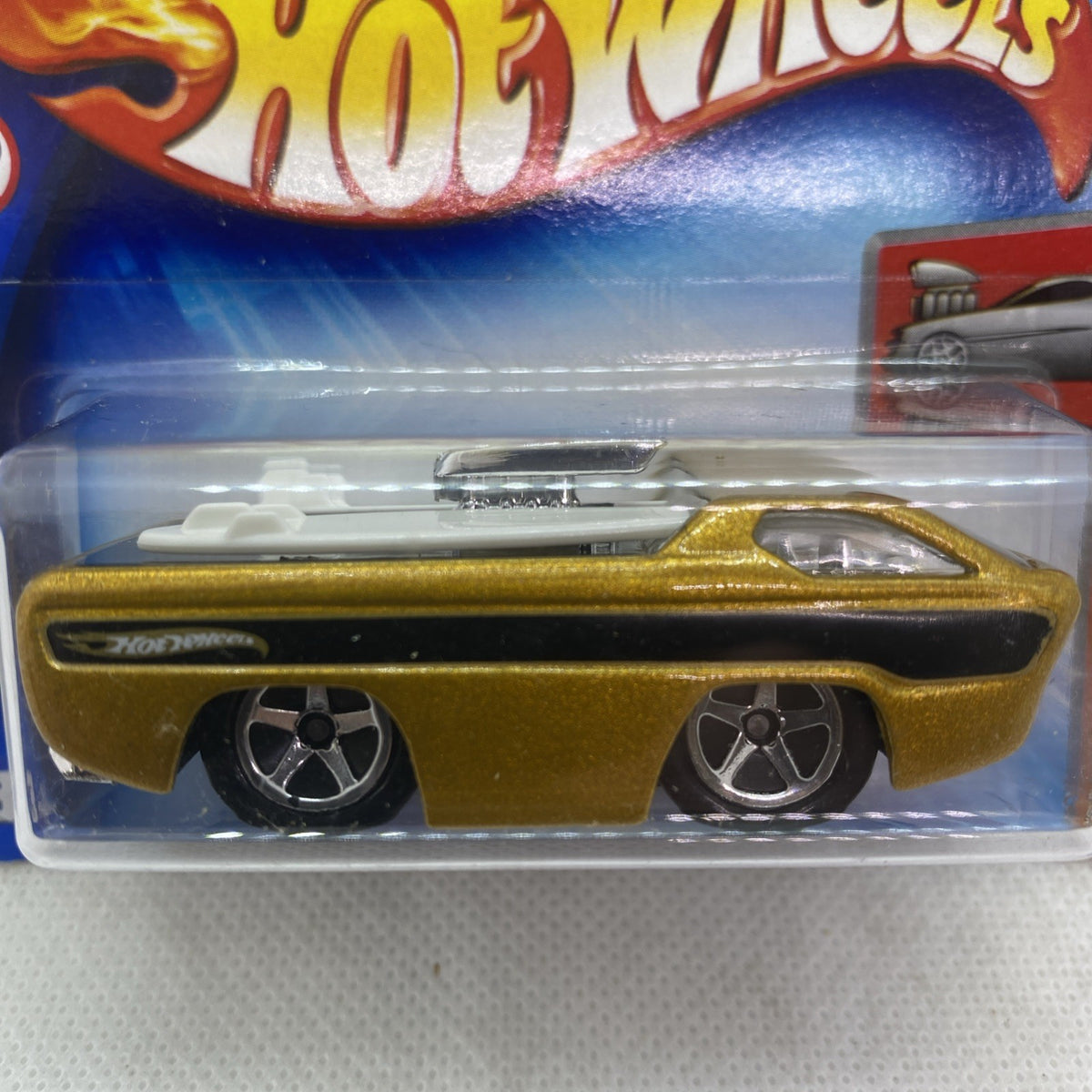 Gold Hot Wheels car with black base and chrome details, blister close-up