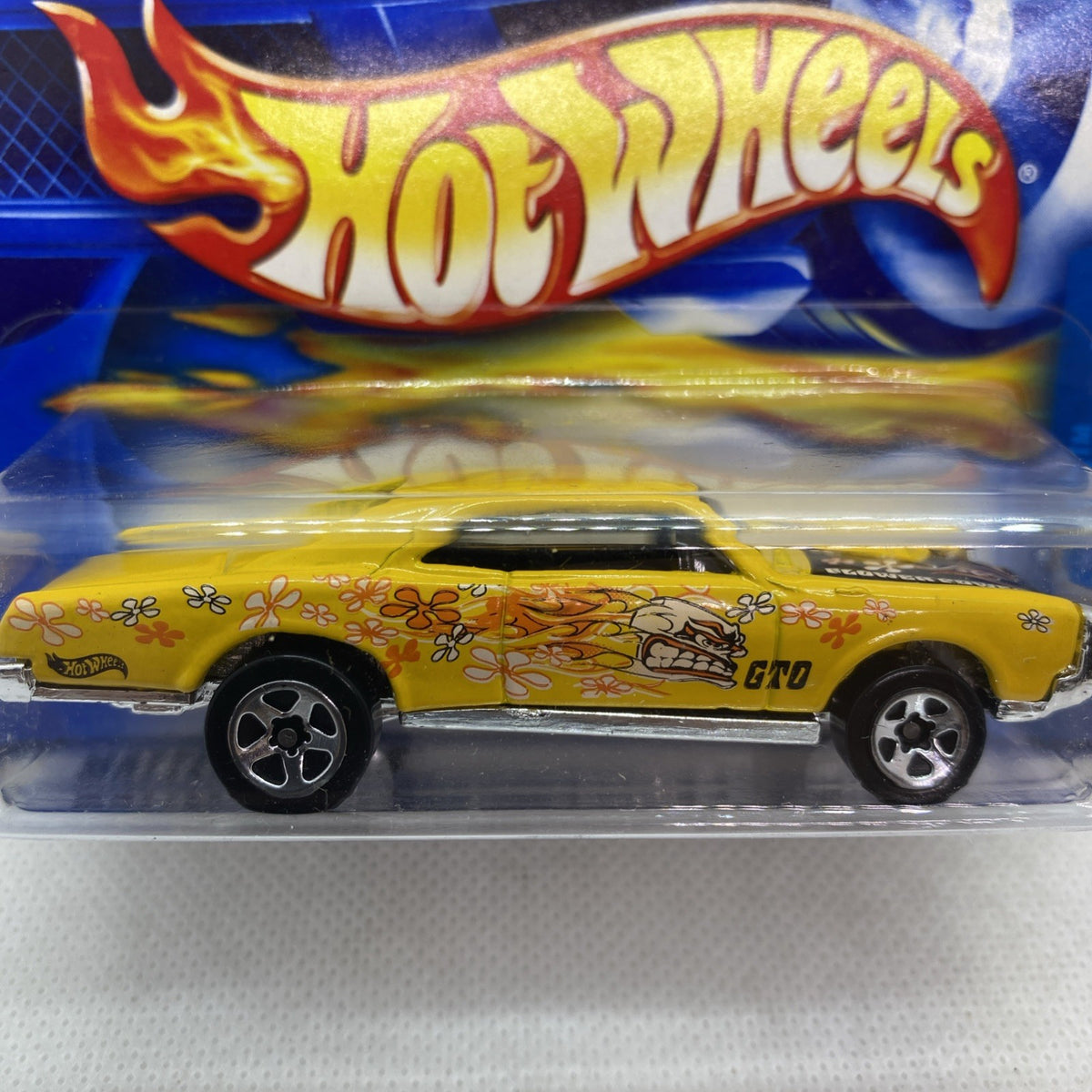 Yellow Hot Wheels Pontiac GTO die-cast with flower graphics, in clear blister