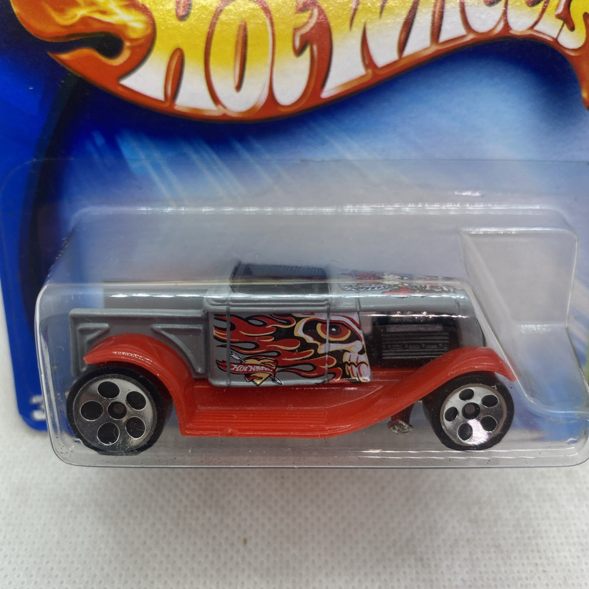 Hot Wheels Hooligan die-cast car close-up in clear blister, red wheels and flame graphics