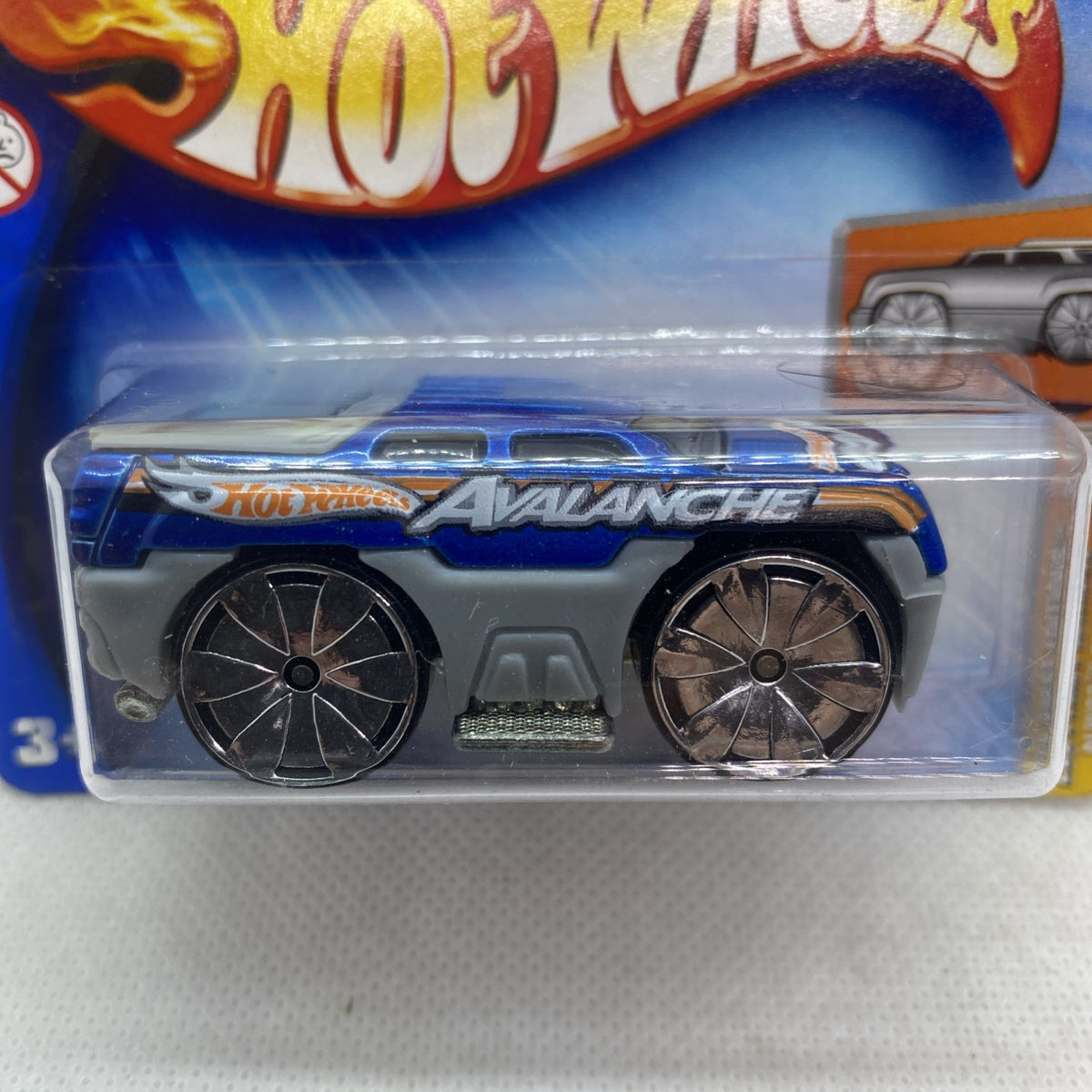 Hot Wheels die-cast pickup car close-up, blue body with silver multi-spoke wheels