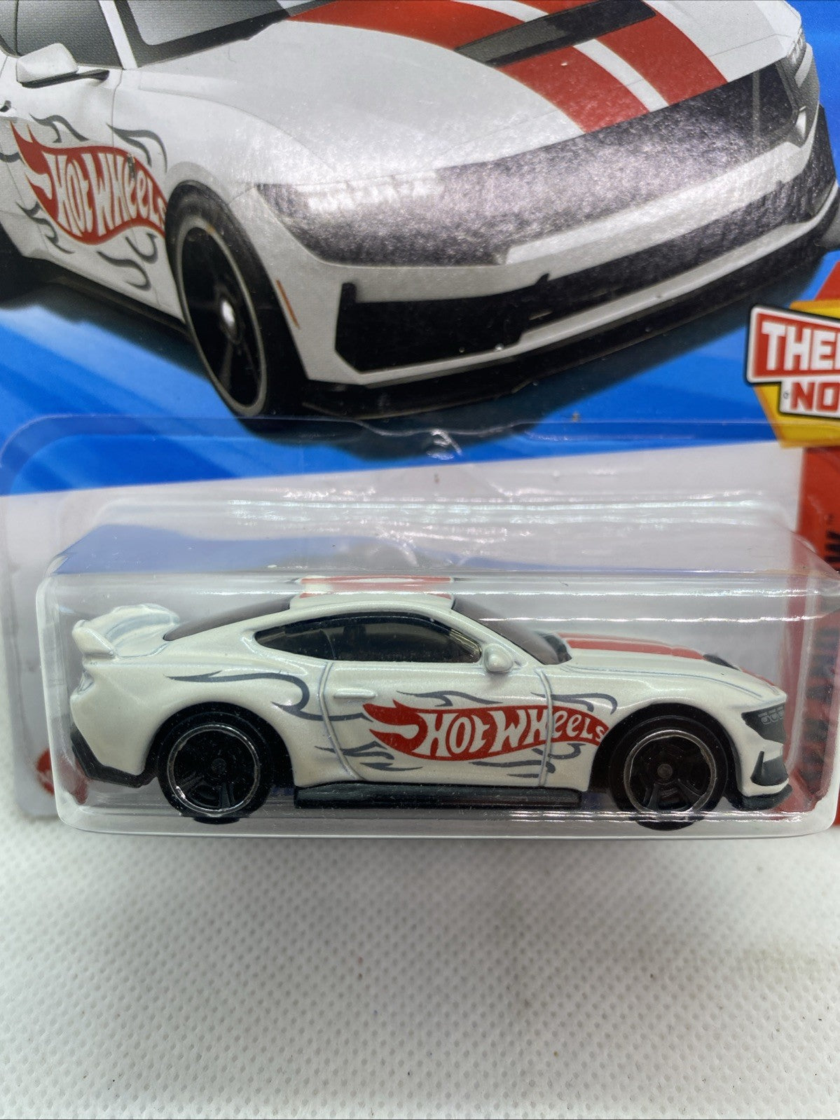 Close-up of Hot Wheels die-cast Mustang with red Hot Wheels flame decals and black rims