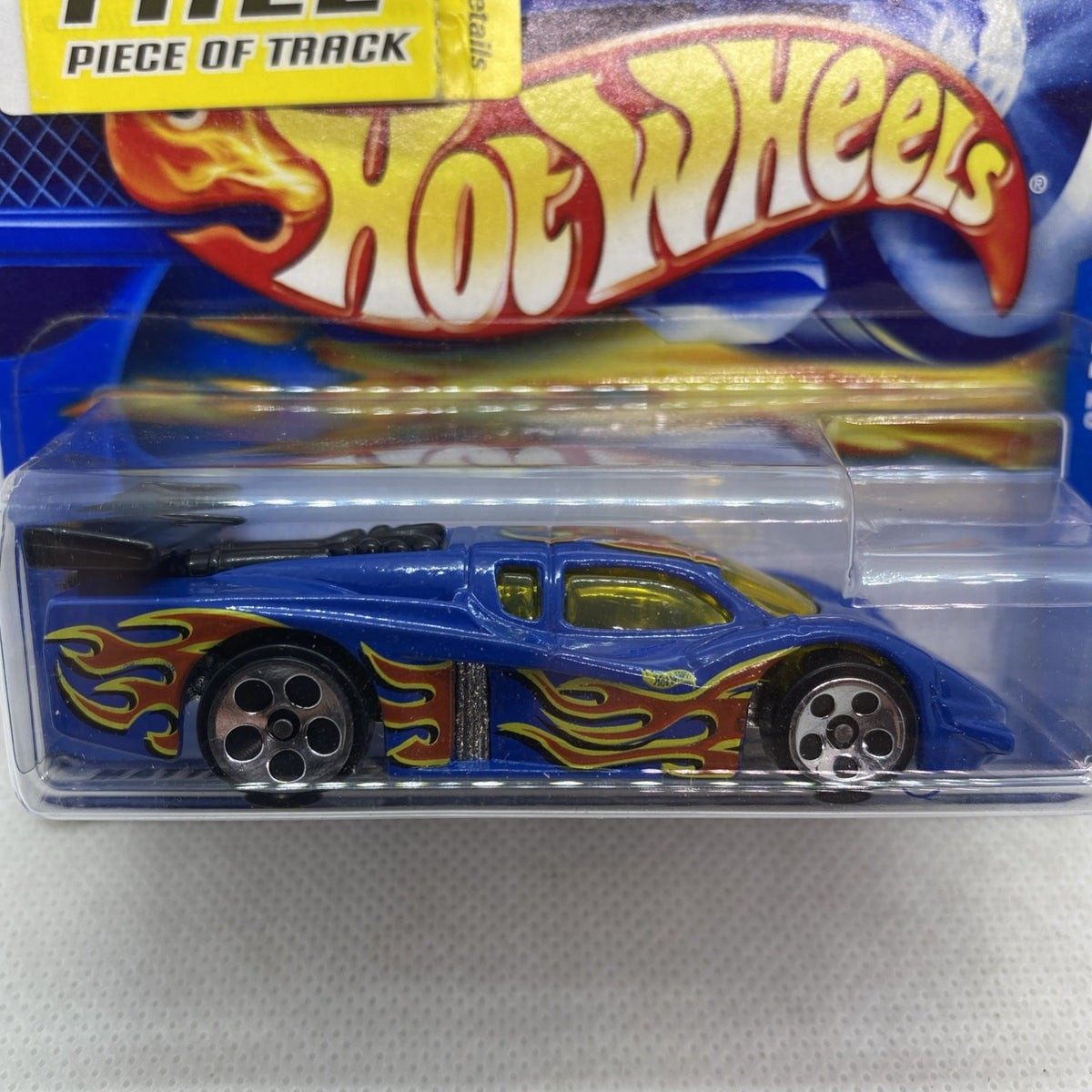 Hot Wheels GT Racer 2001 blue die-cast car blister, flame decals, close-up of front.