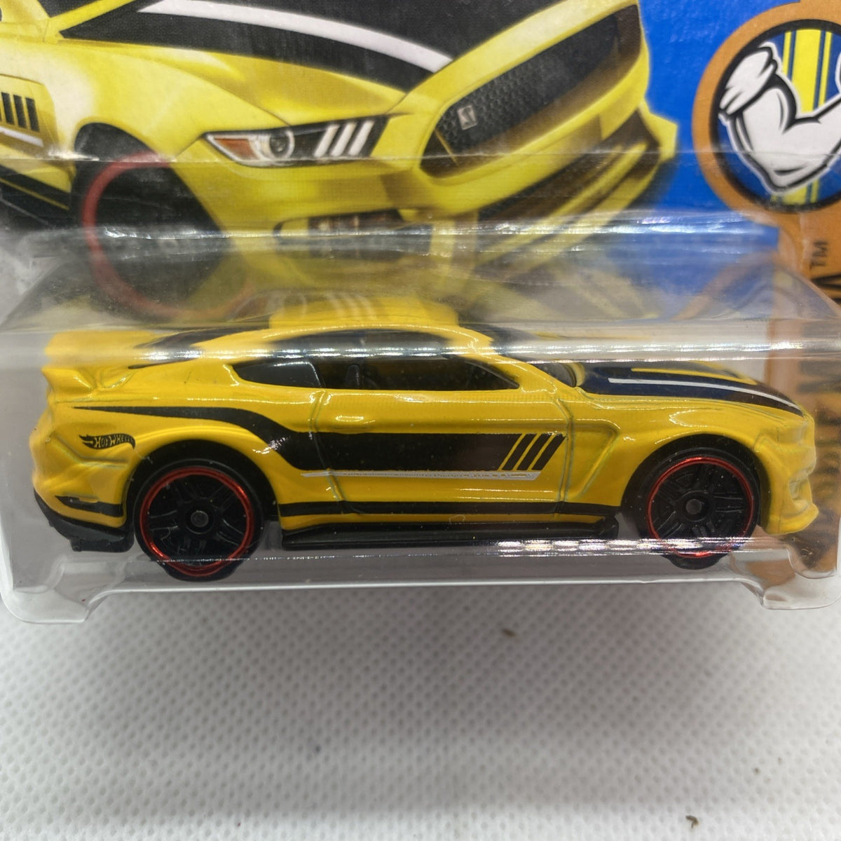 Close-up of yellow Hot Wheels muscle car in clear blister, side profile