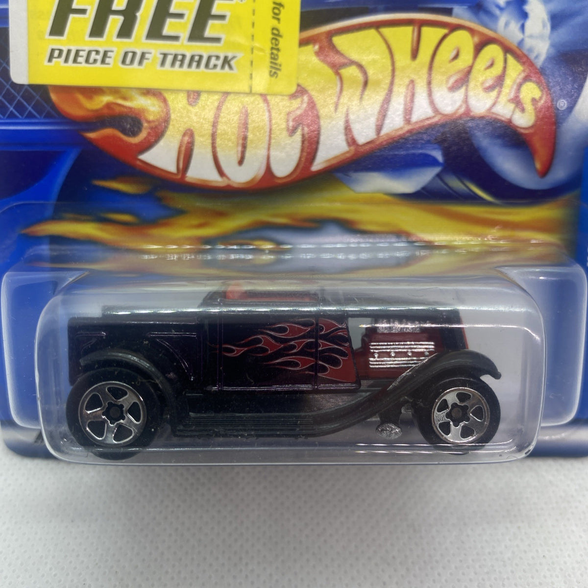 Hot Wheels Hooligan #203 die-cast car close-up in blue blister, black with red flames