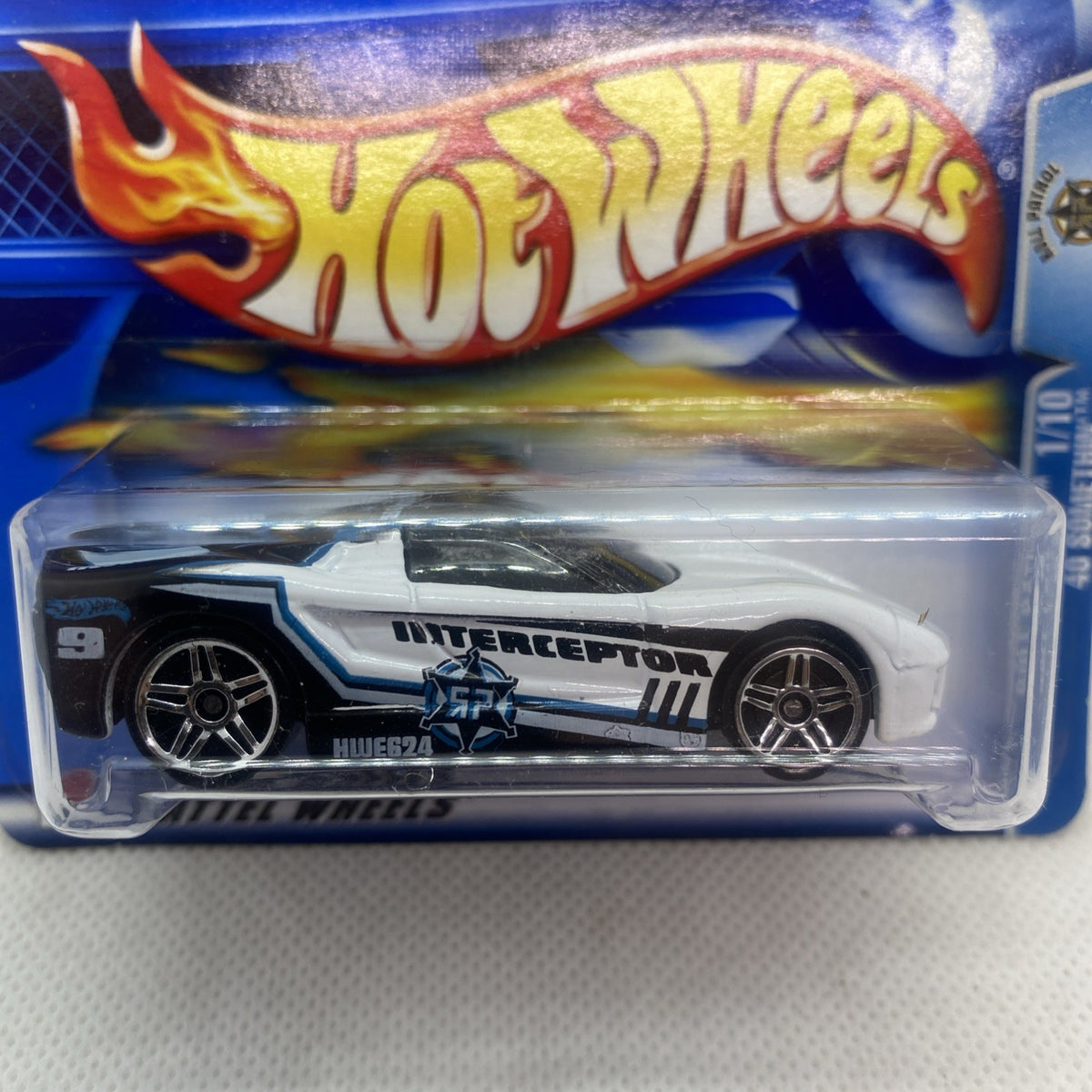 Hot Wheels Interceptor die-cast car close-up, white body with black 'INTERCEPTOR' print