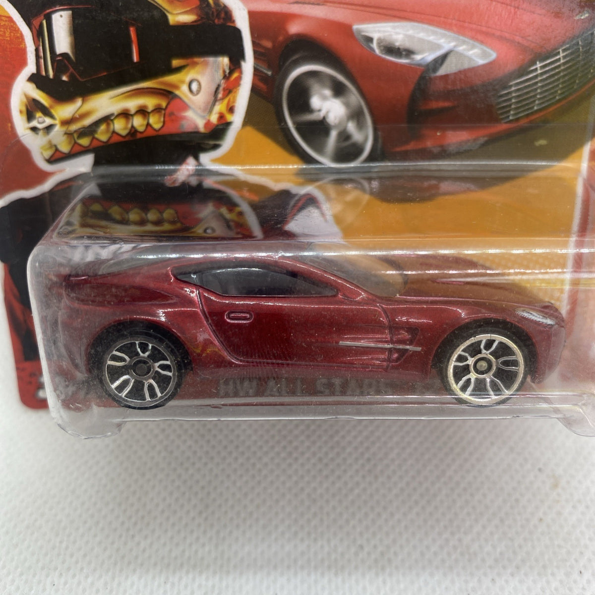 Close-up of red Aston Martin One-77 diecast with detailed wheels in clear blister