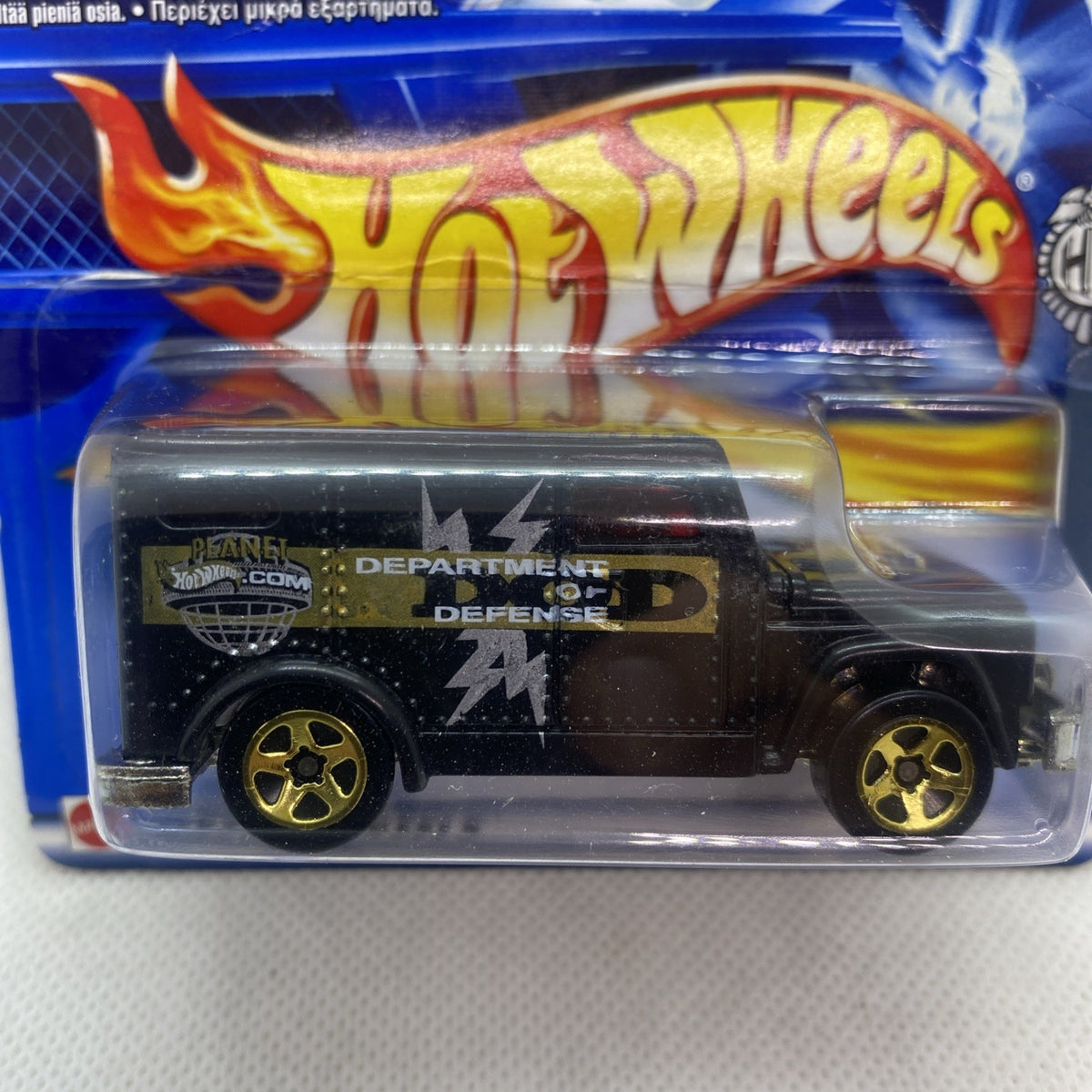 Hot Wheels armored truck die-cast close-up in clear blister, black body and gold wheels