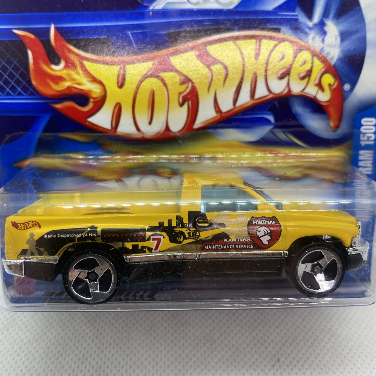 Hot Wheels Dodge Ram 1500 toy close-up in blister, yellow truck with sponsor decals.