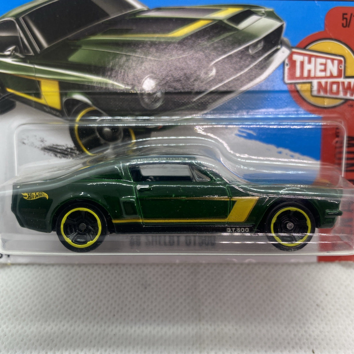 Close-up of Hot Wheels green toy car with yellow stripe in clear blister