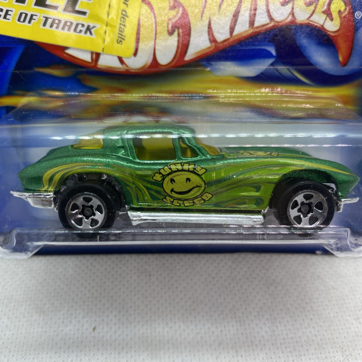 Hot Wheels green die-cast car with smile face graphic in clear blister, side view