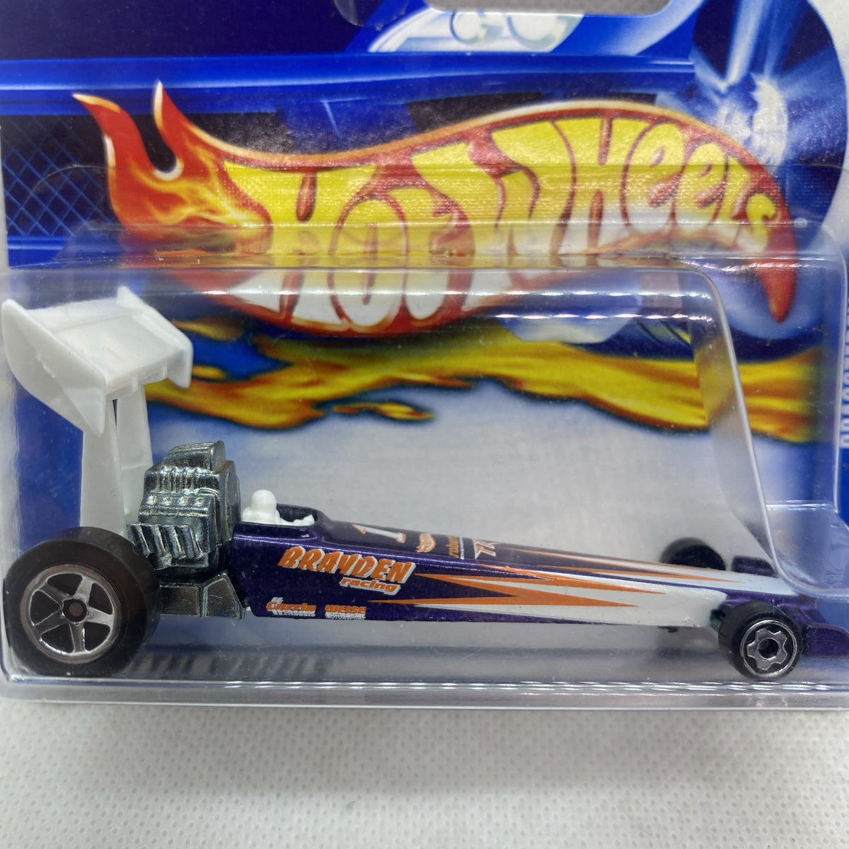 Close-up of die-cast dragster in clear blister with flame livery on blue Hot Wheels card.