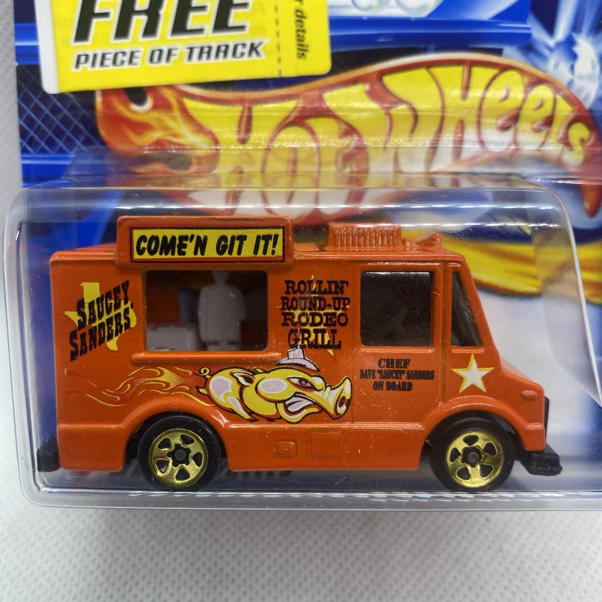 Orange toy truck close-up in clear blister with flame graphics and “Come’n Git It!”