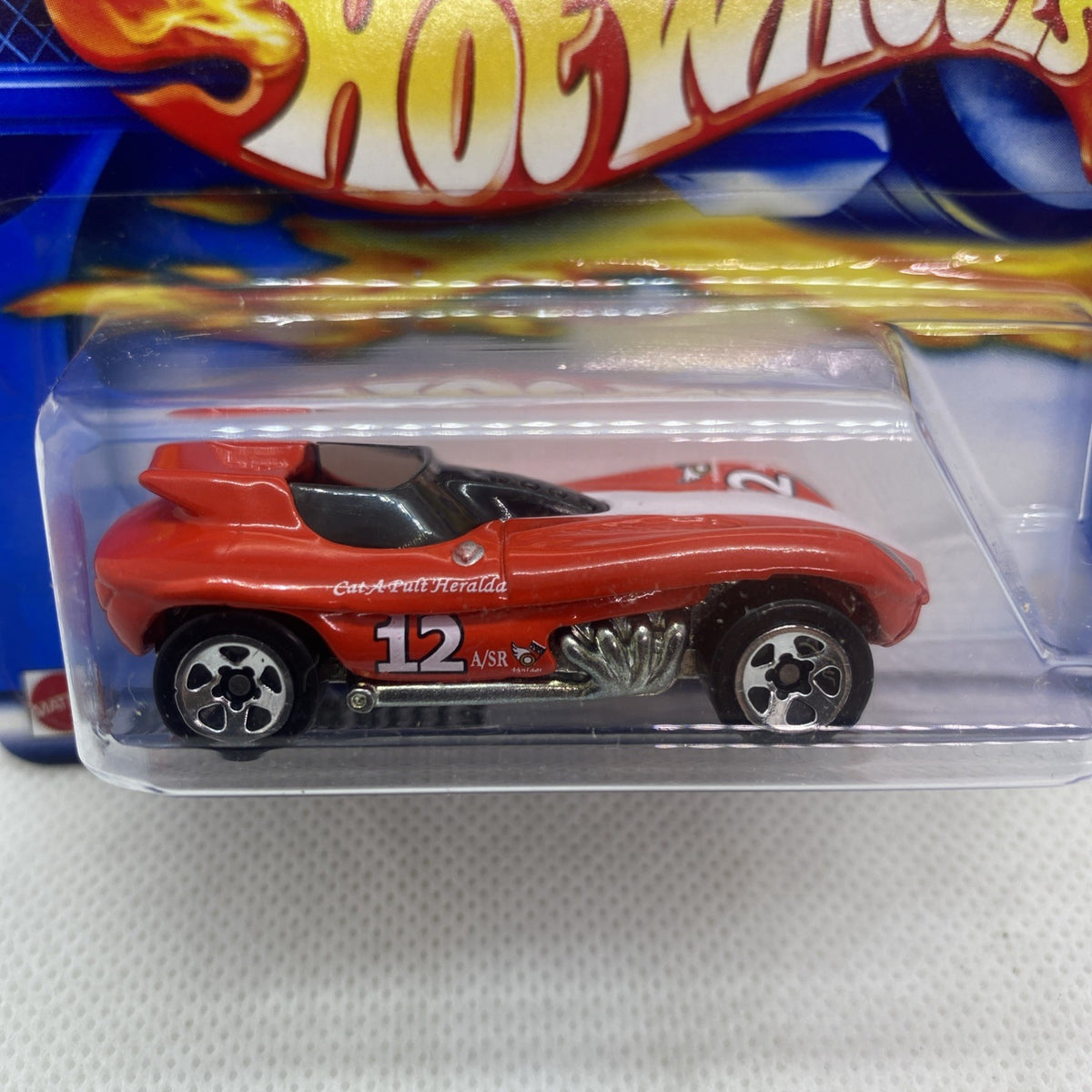 Close-up of Hot Wheels red die-cast car with black wheels in clear blister