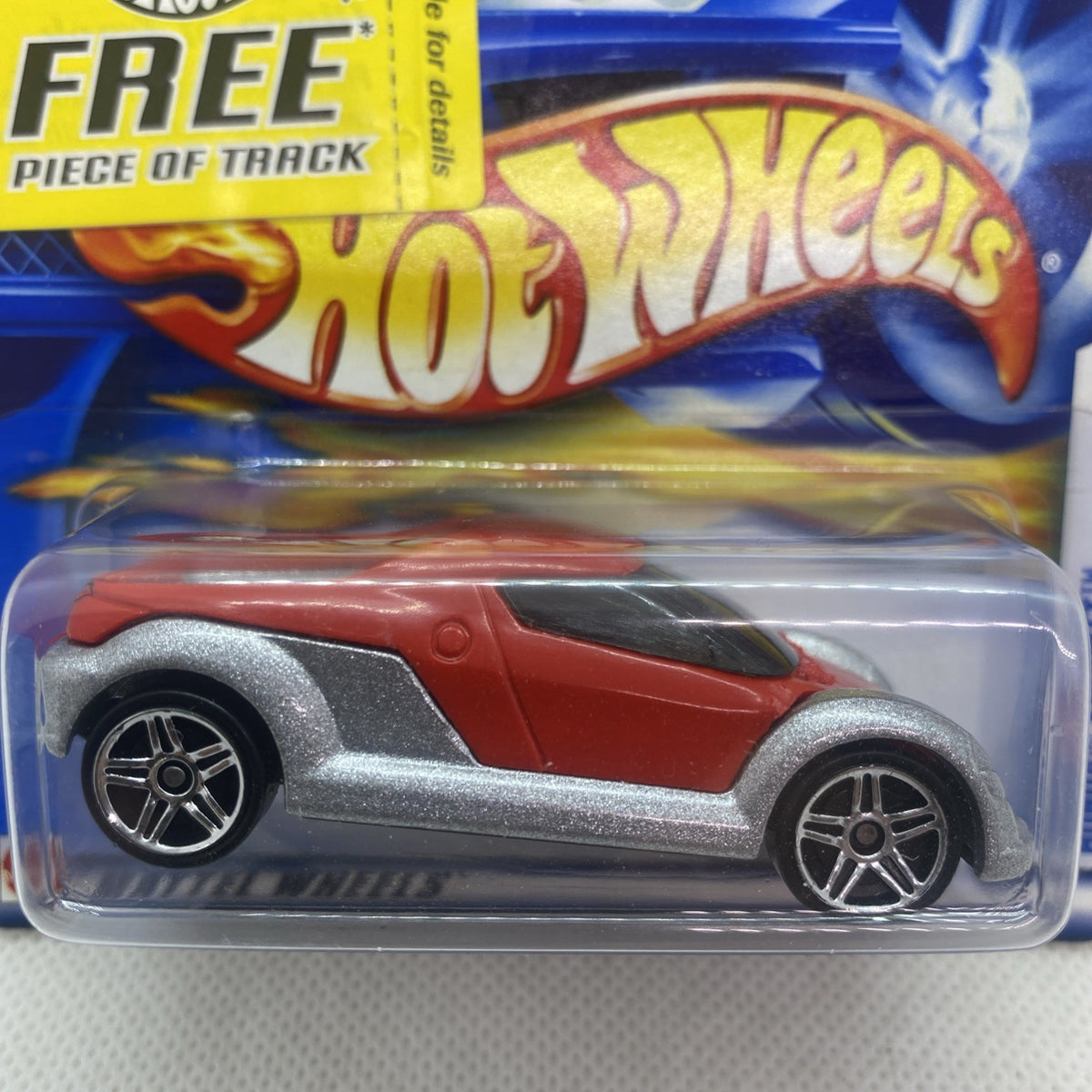 Hot Wheels die-cast car close-up in blister, red top and gray body with black stripe