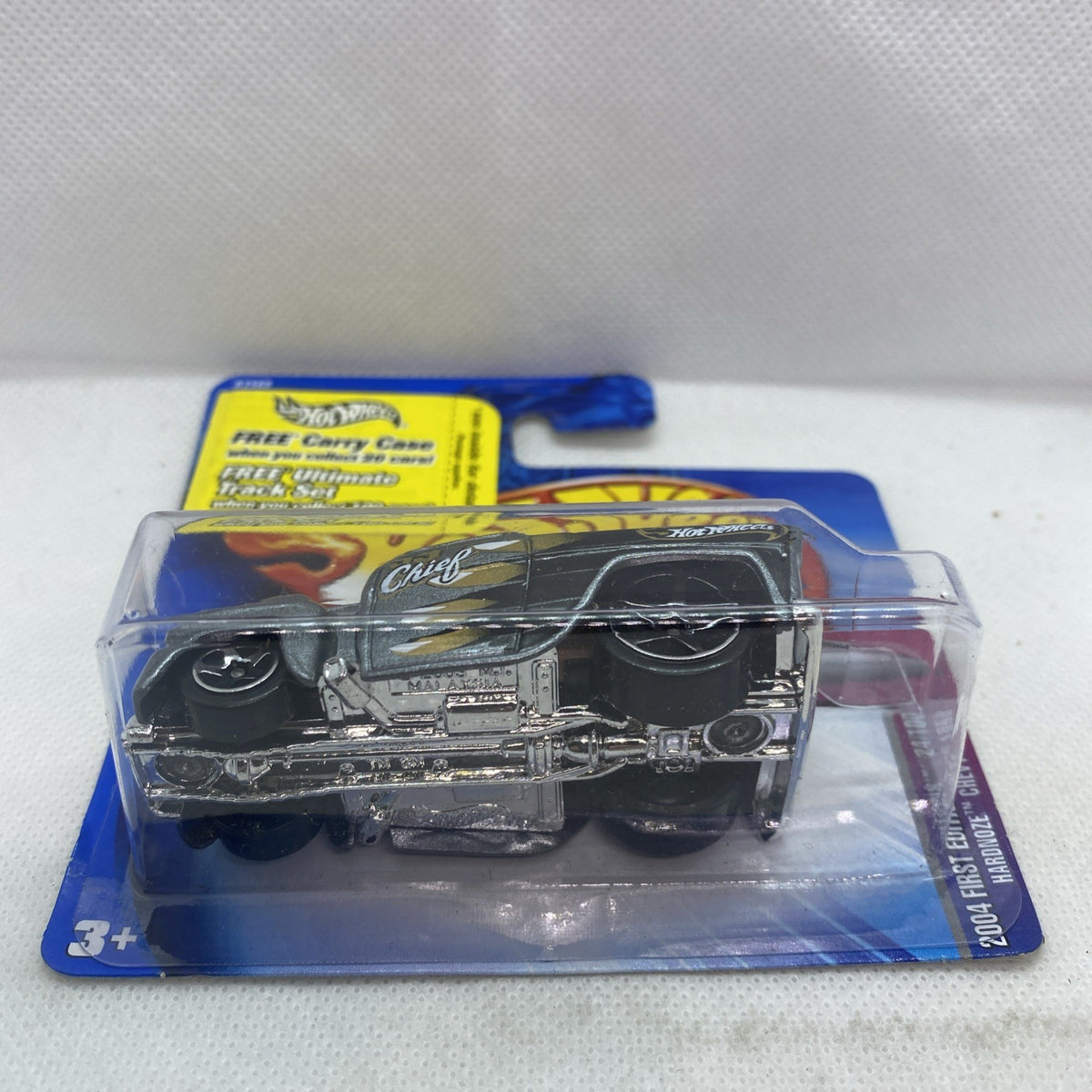 Toy die-cast car in clear blister on blue card, front view of dark gray truck