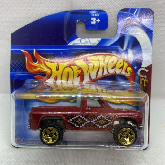 Hot Wheels die-cast pickup in blister pack, maroon body with flame graphics and yellow wheels