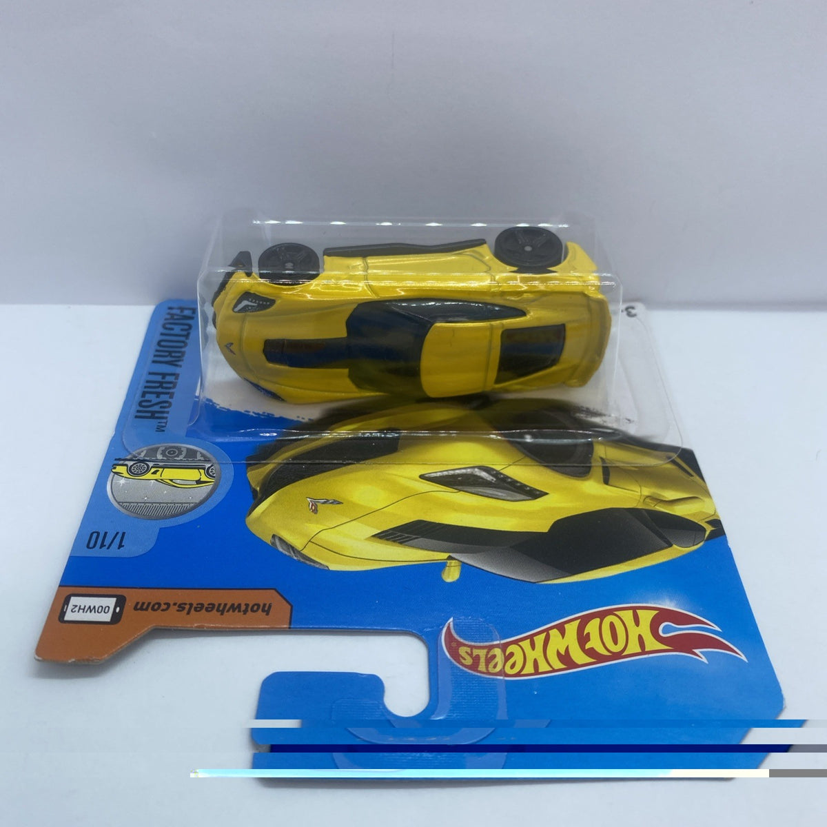 Yellow Hot Wheels diecast Corvette C7 Z06 car with black hood stripe in blue card