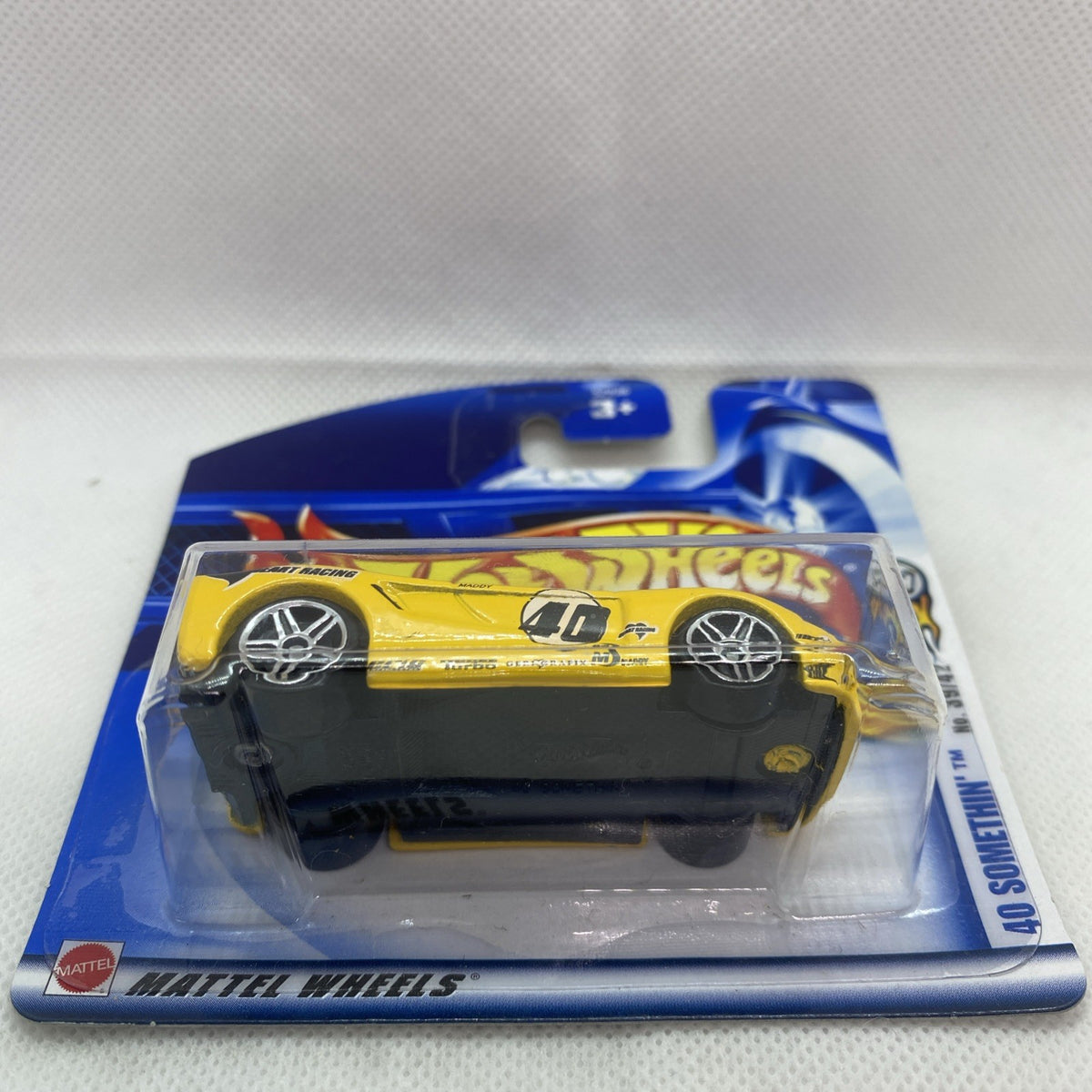 Sealed yellow Hot Wheels die-cast car blister on card, side view with black base