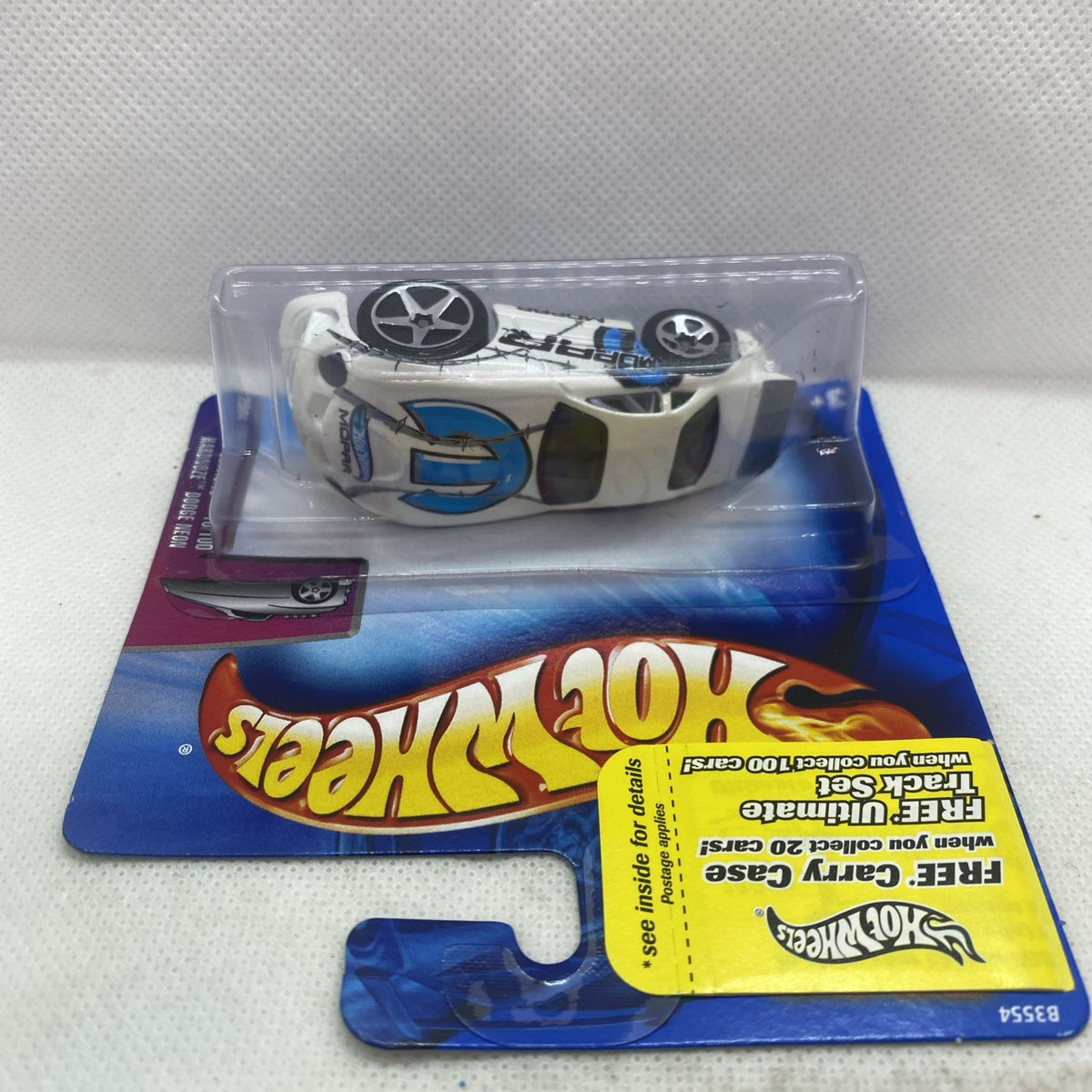 Hot Wheels blister pack showing a white and black race car with star-spoke wheels