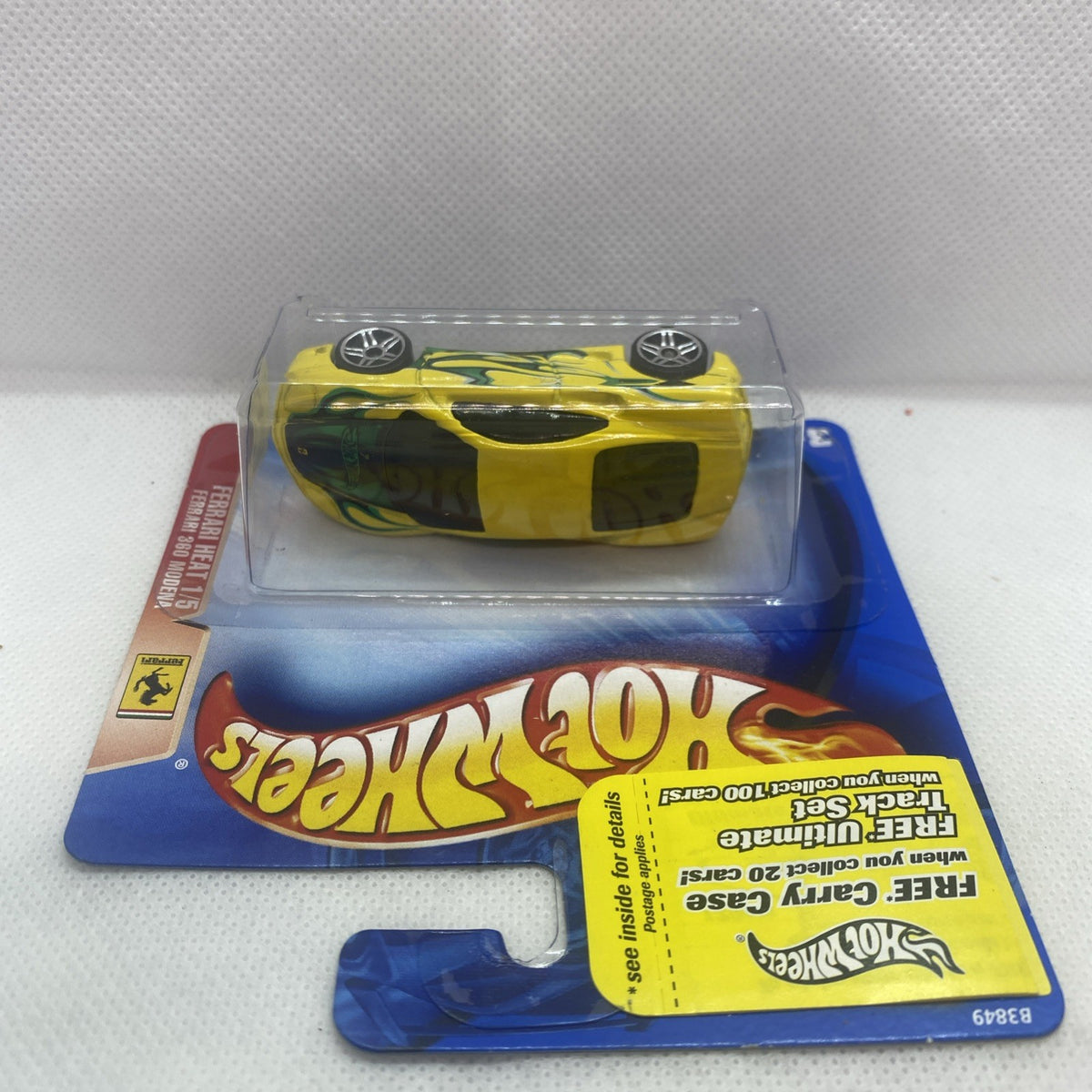 Yellow Ferrari-style die-cast car in clear blister with flame decals and wheels