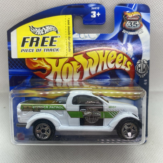 Hot Wheels die-cast truck in blister card, white body with green stripe, side view