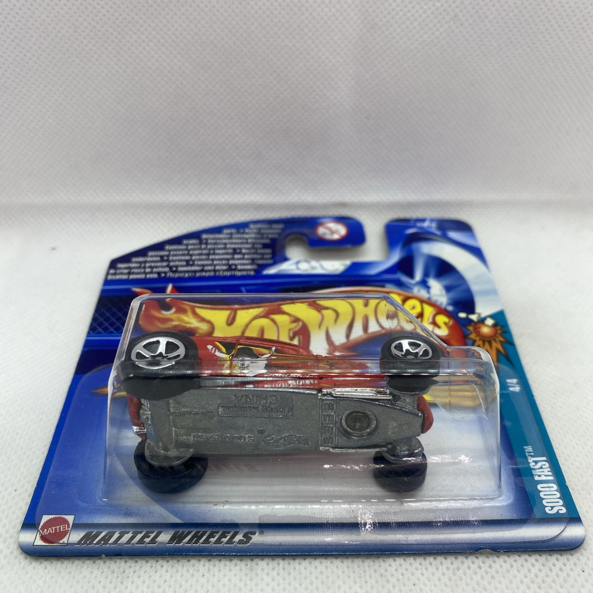Hot Wheels die-cast red car in blister pack with chassis view through plastic