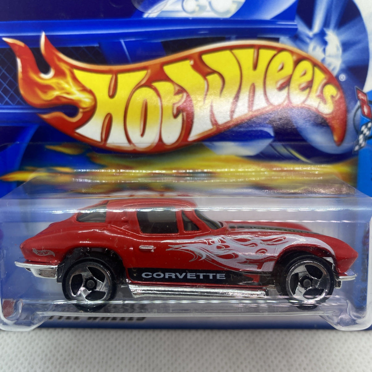 Hot Wheels Corvette die-cast close-up, red body with white flames and Corvette badge