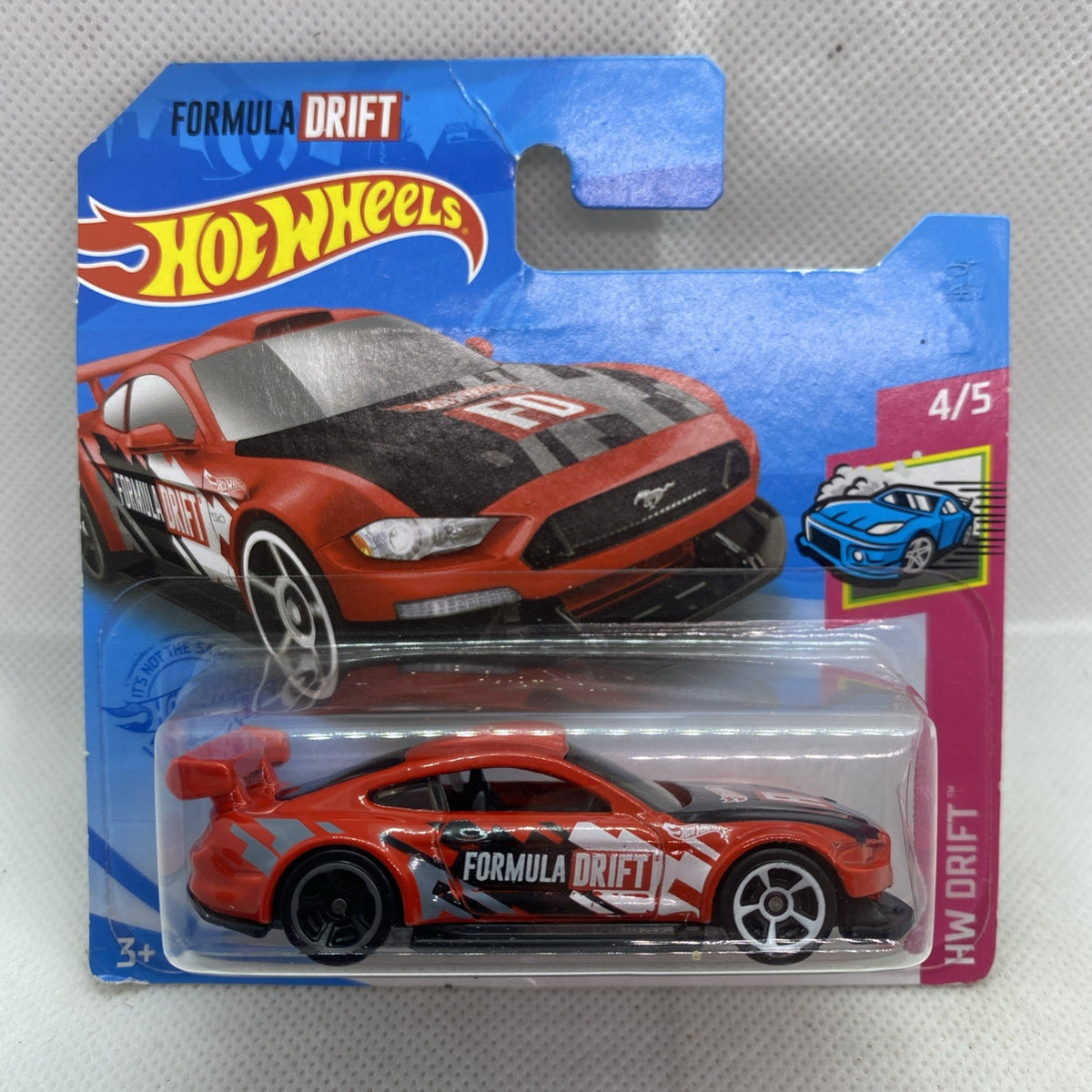 Hot Wheels Formula Drift die-cast car, orange with white graphics, sealed on card