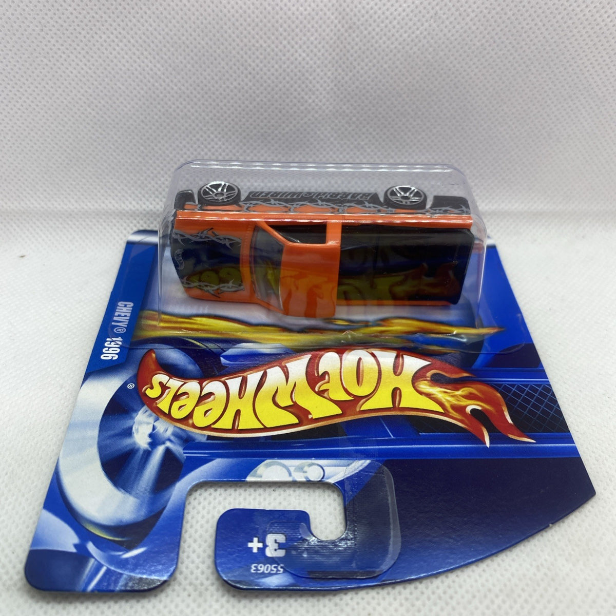 Hot Wheels die-cast pickup in blister card, top view with wheels and orange cab