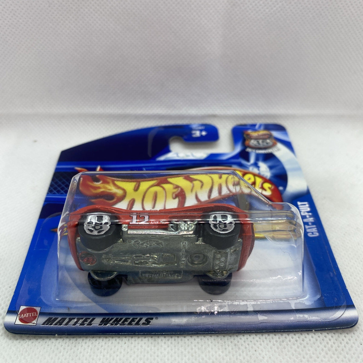 Hot Wheels red die-cast car blister, front view, on blue short card