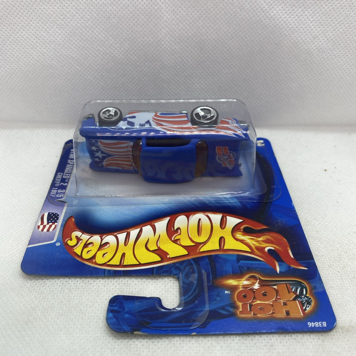 Die-cast car in blue Hot Wheels blister, top view with flame graphics and silver wheels