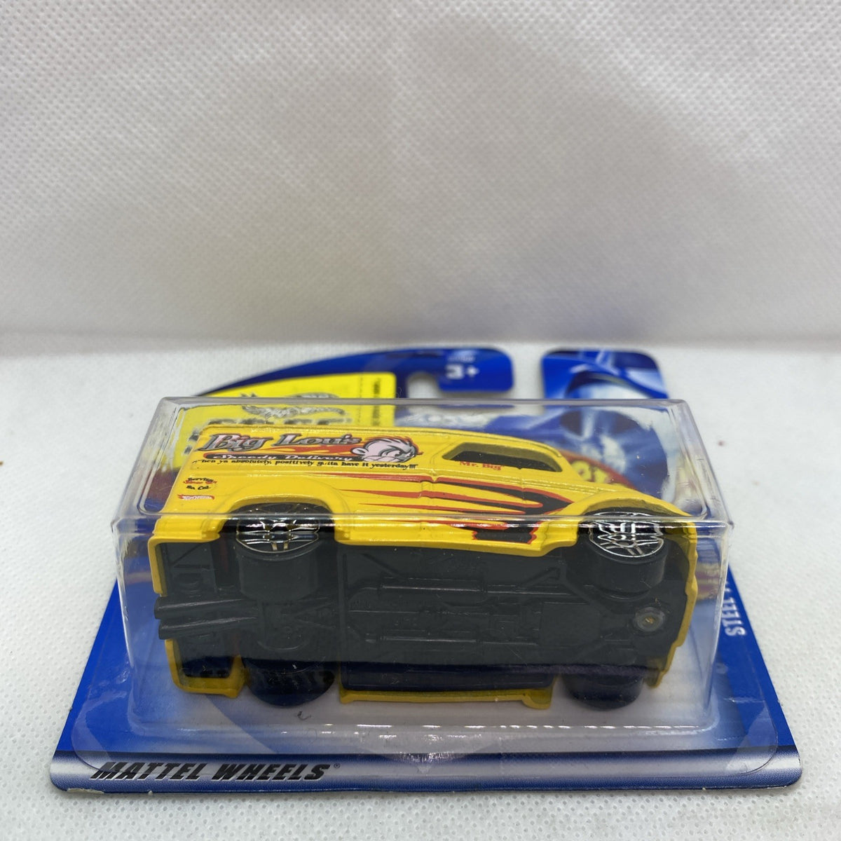 Yellow Hot Wheels die-cast car blister pack, side profile with black wheels.