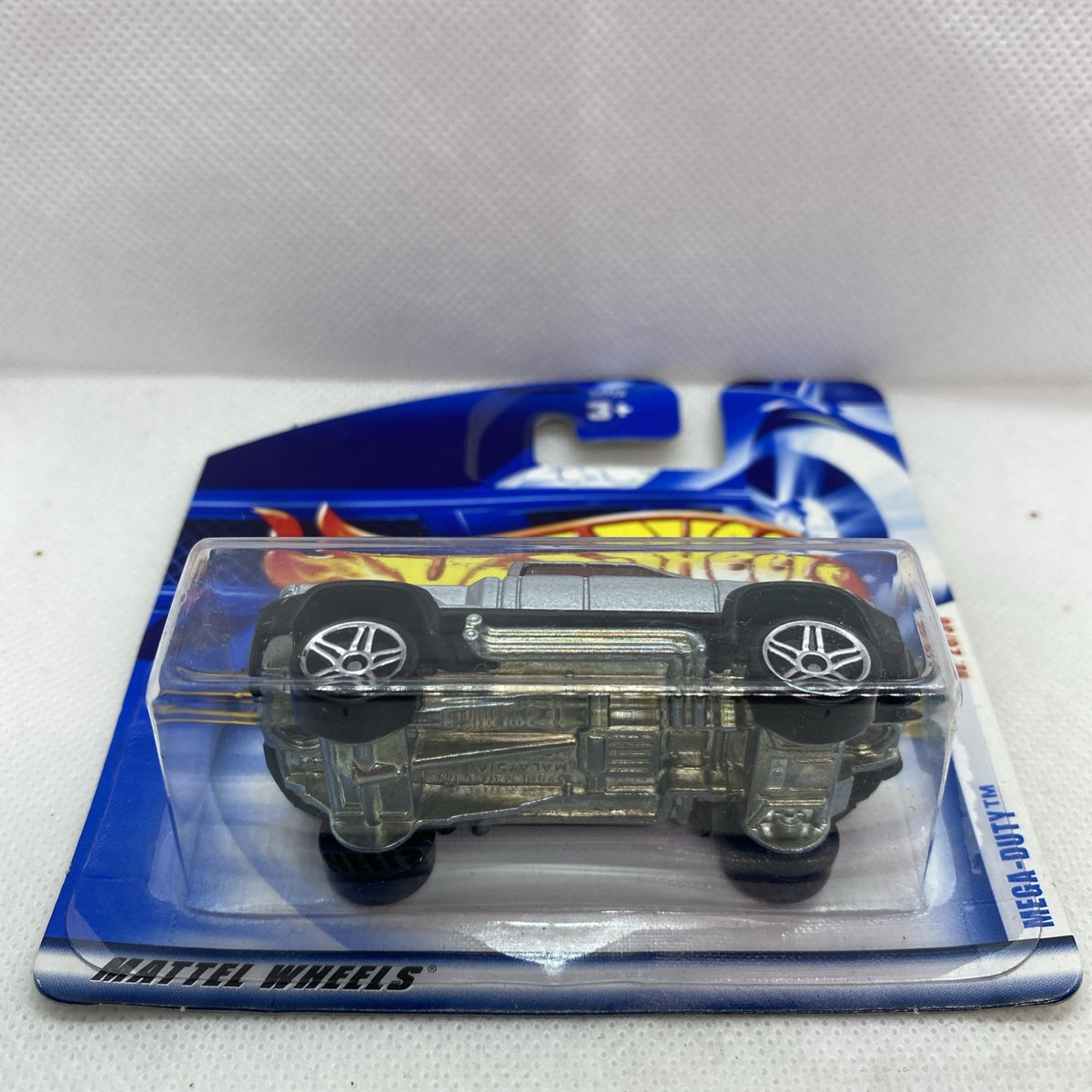 Silver die-cast pickup truck on blue card, front view in clear blister