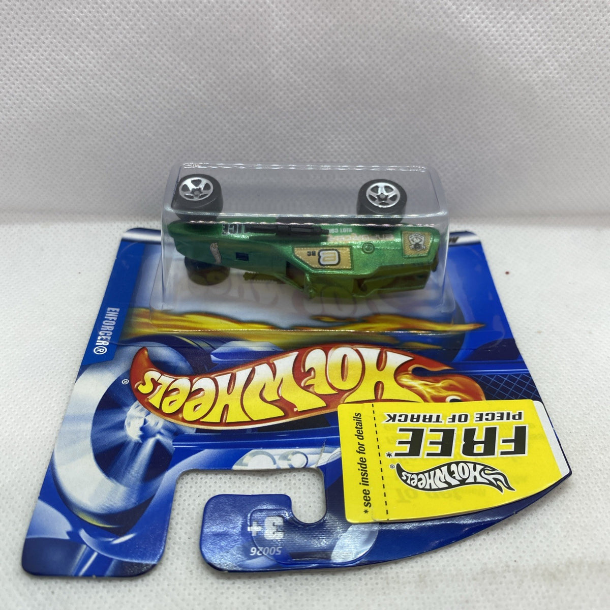 Hot Wheels Enforcer short card blister with green and black toy car, front angle