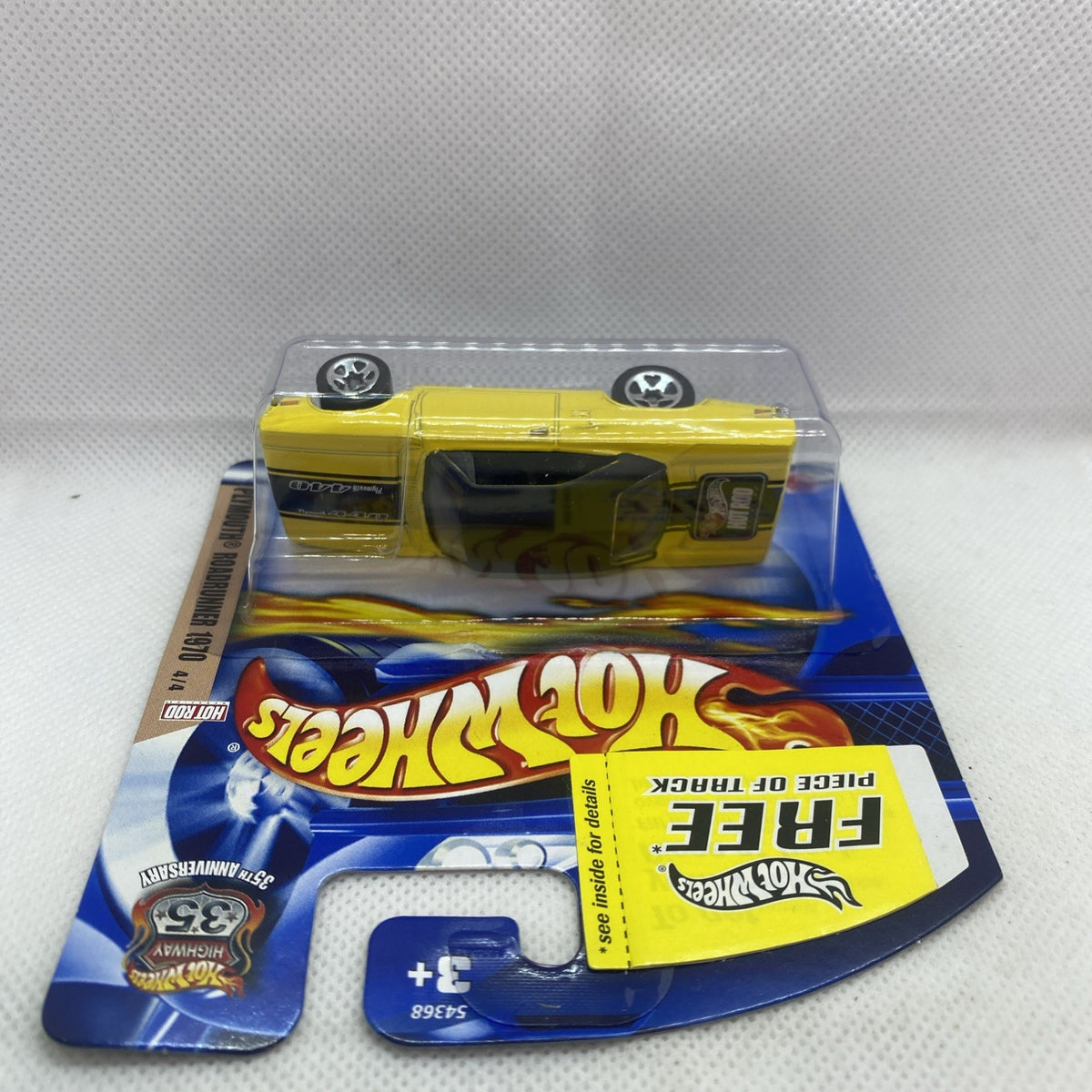 Yellow die-cast Roadrunner 1970 car with black hood and chrome chassis, carded