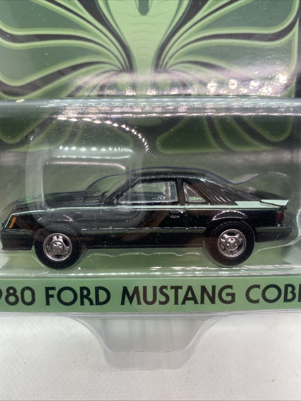 Black die-cast Mustang Cobra model car with front grille detail in blister