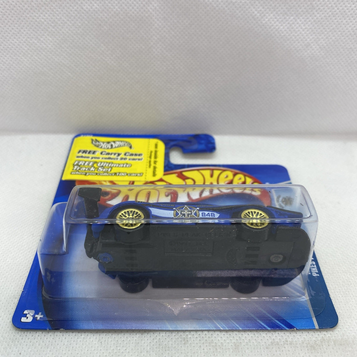 Hot Wheels blue die-cast car in clear blister on card, side view with wheels
