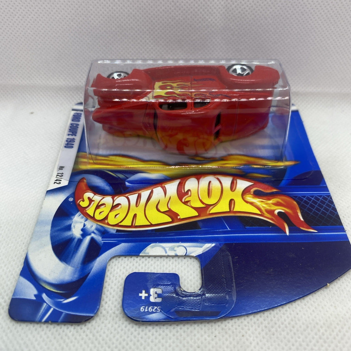 Hot Wheels red flame coupe in clear blister on blue short card, angled view