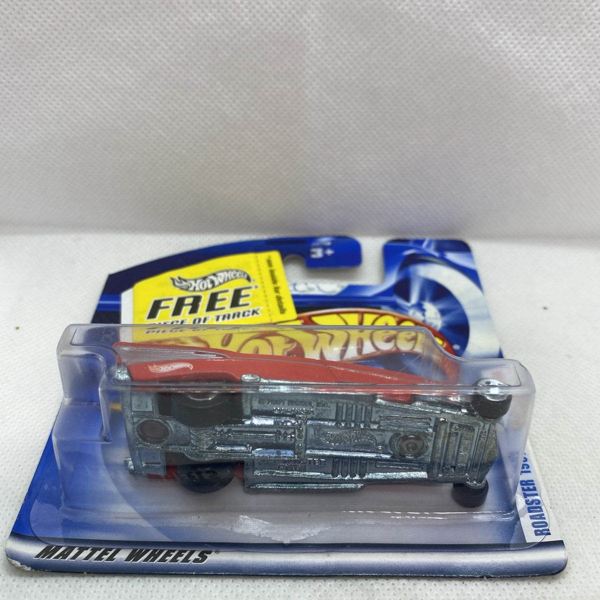 Hot Wheels ’57 Roadster die-cast car in blister with “FREE piece of track” banner