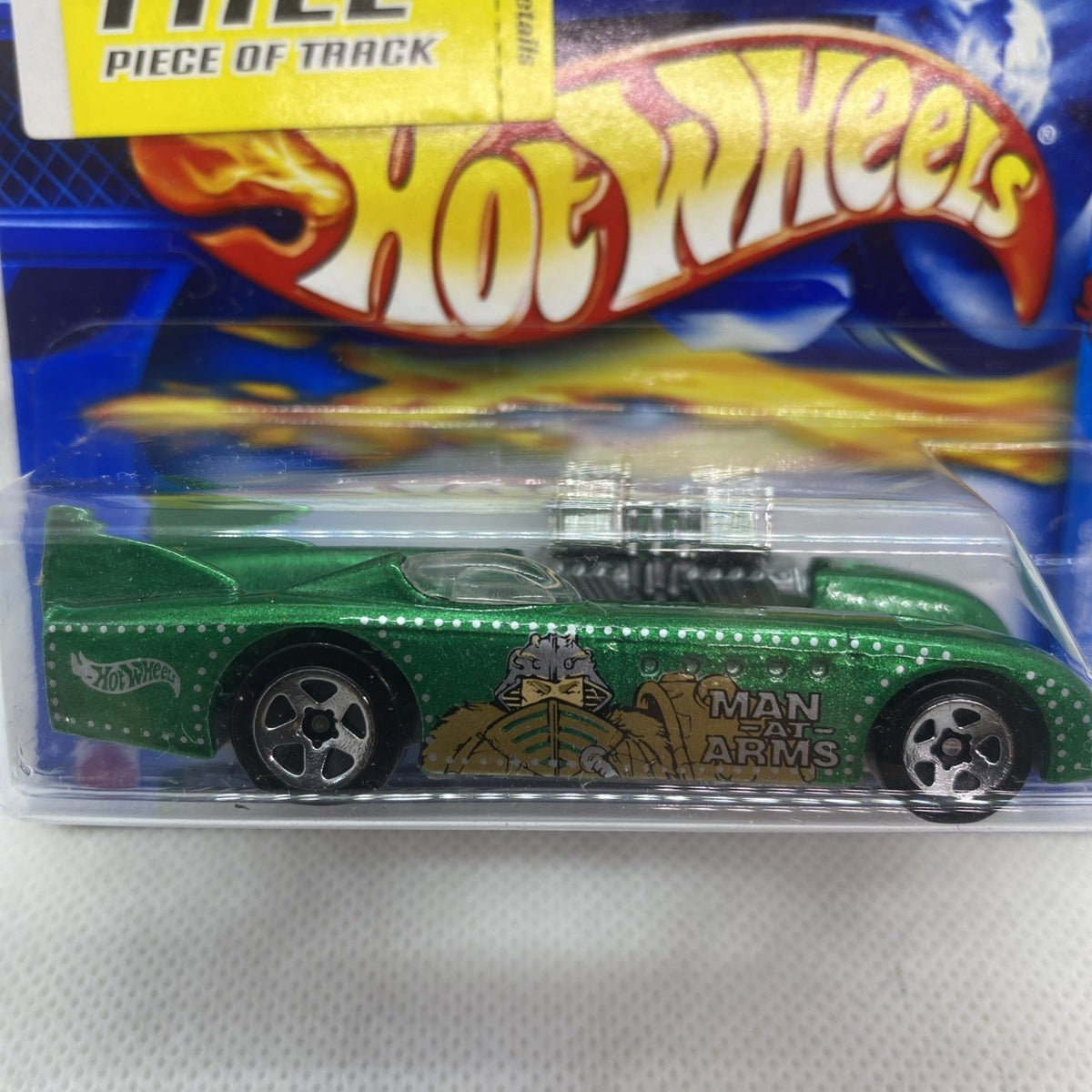 Close view of carded green Hot Wheels vehicle with black wheels and clear blister