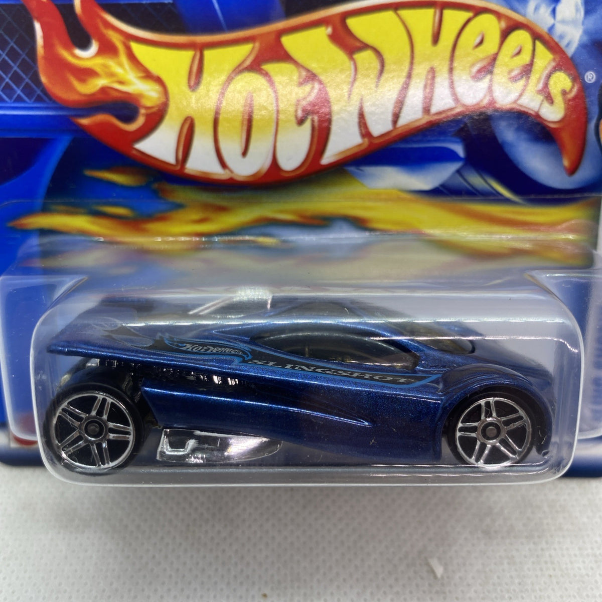 Hot Wheels blue die-cast car on blister pack close-up, flame Hot Wheels graphic