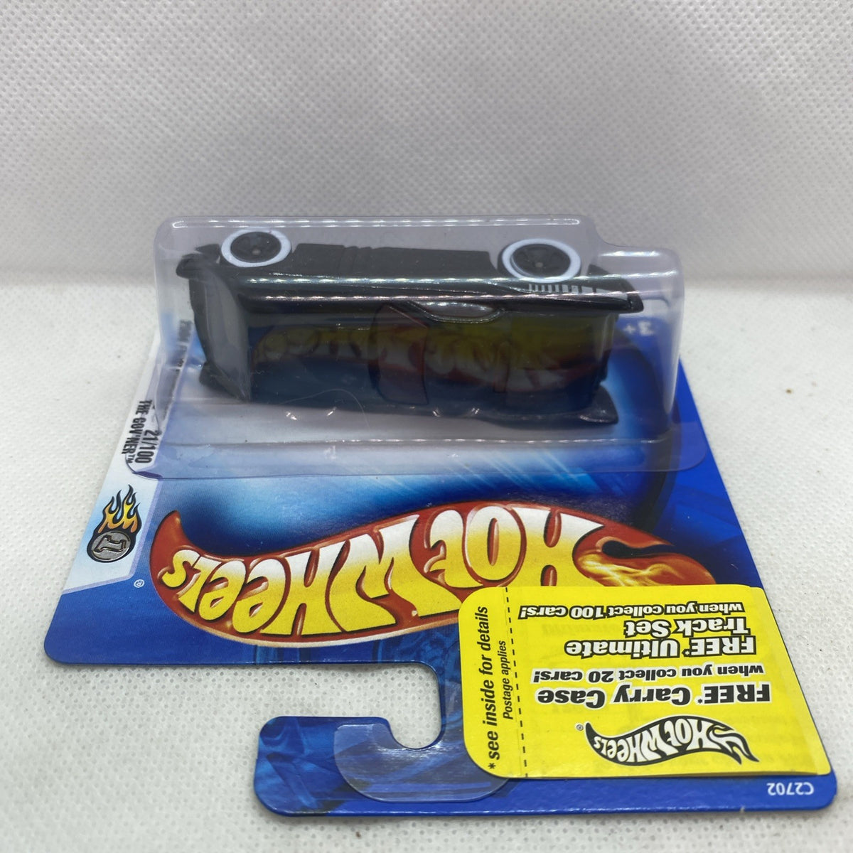 Hot Wheels die-cast car in blister card, black body with yellow flame-style graphics