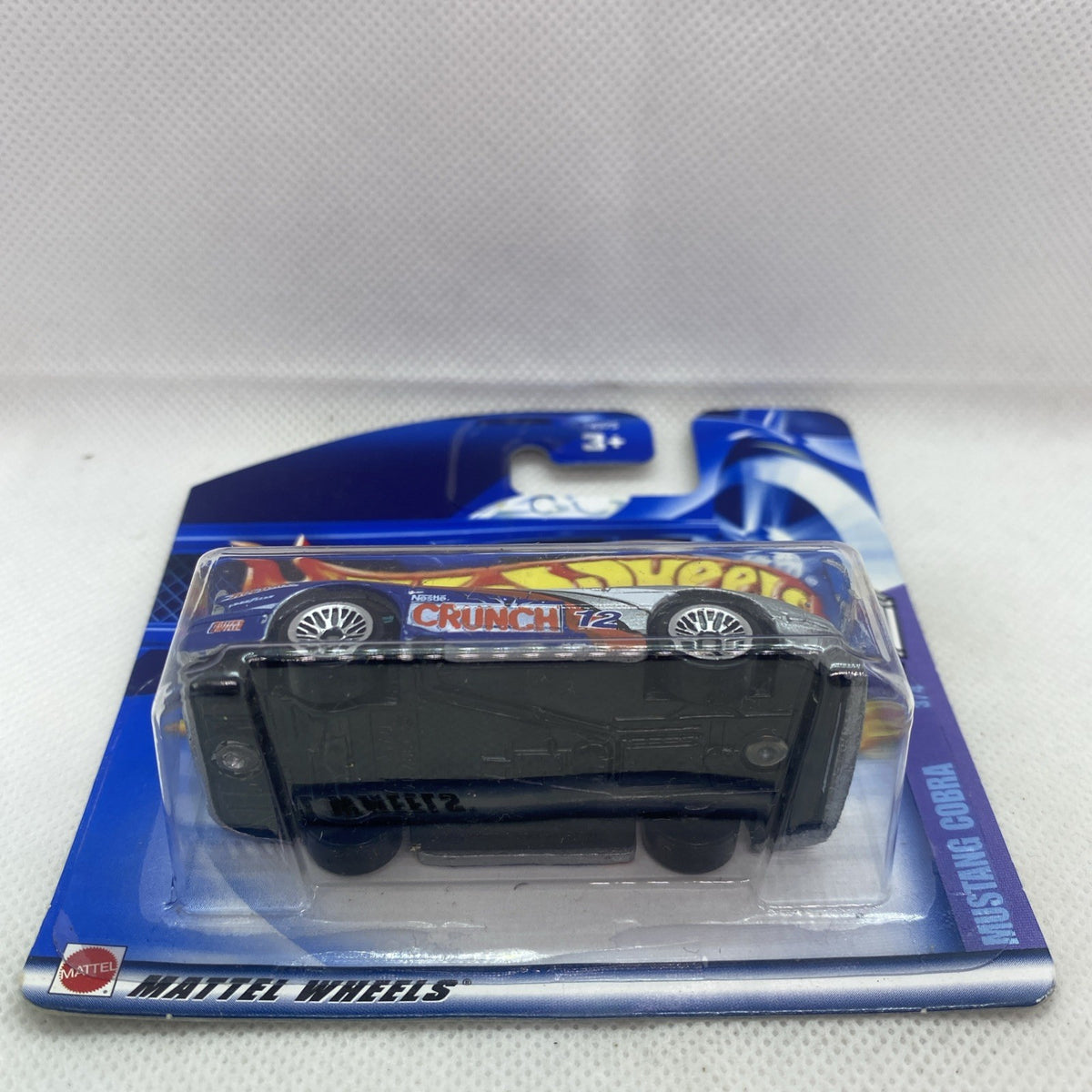 Hot Wheels die-cast car in clear blister showing underside and wheels on blue card