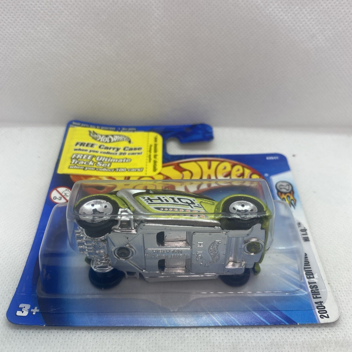 Lime green and silver die-cast car in blister pack, front view with chrome base