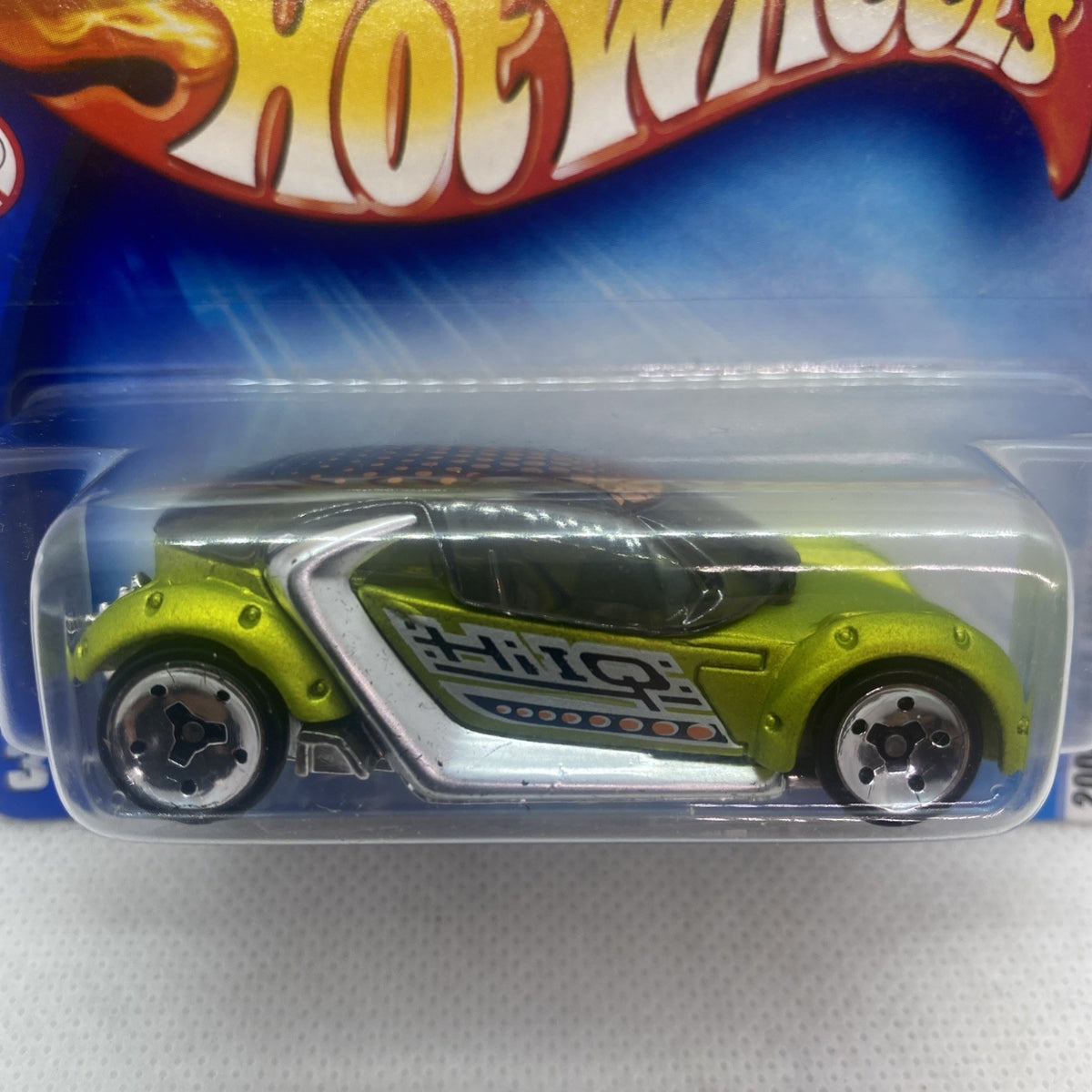 Lime green die-cast car with silver hood and black windshield in clear blister, side view