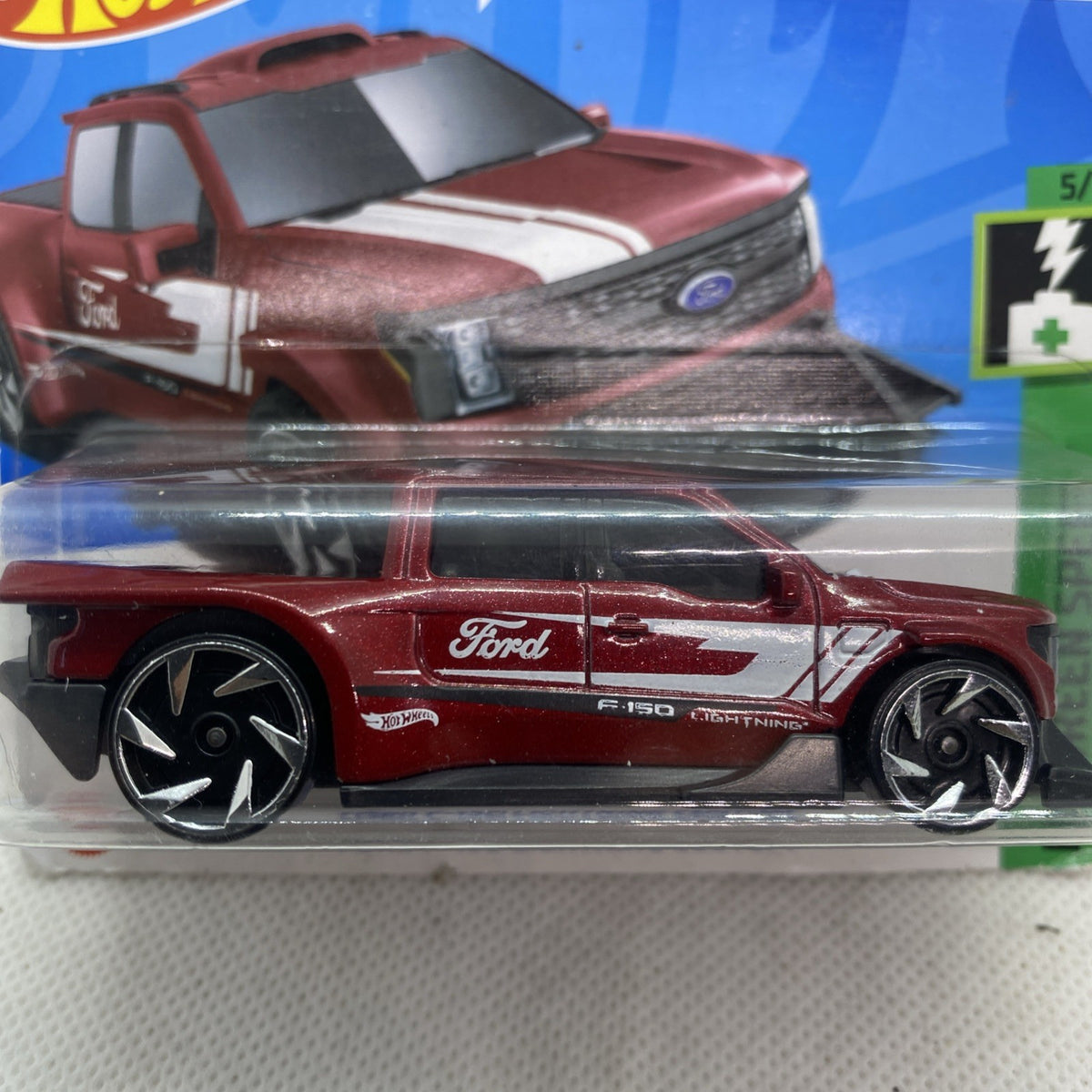 Maroon die-cast pickup truck toy in clear blister, close side view with chrome wheels