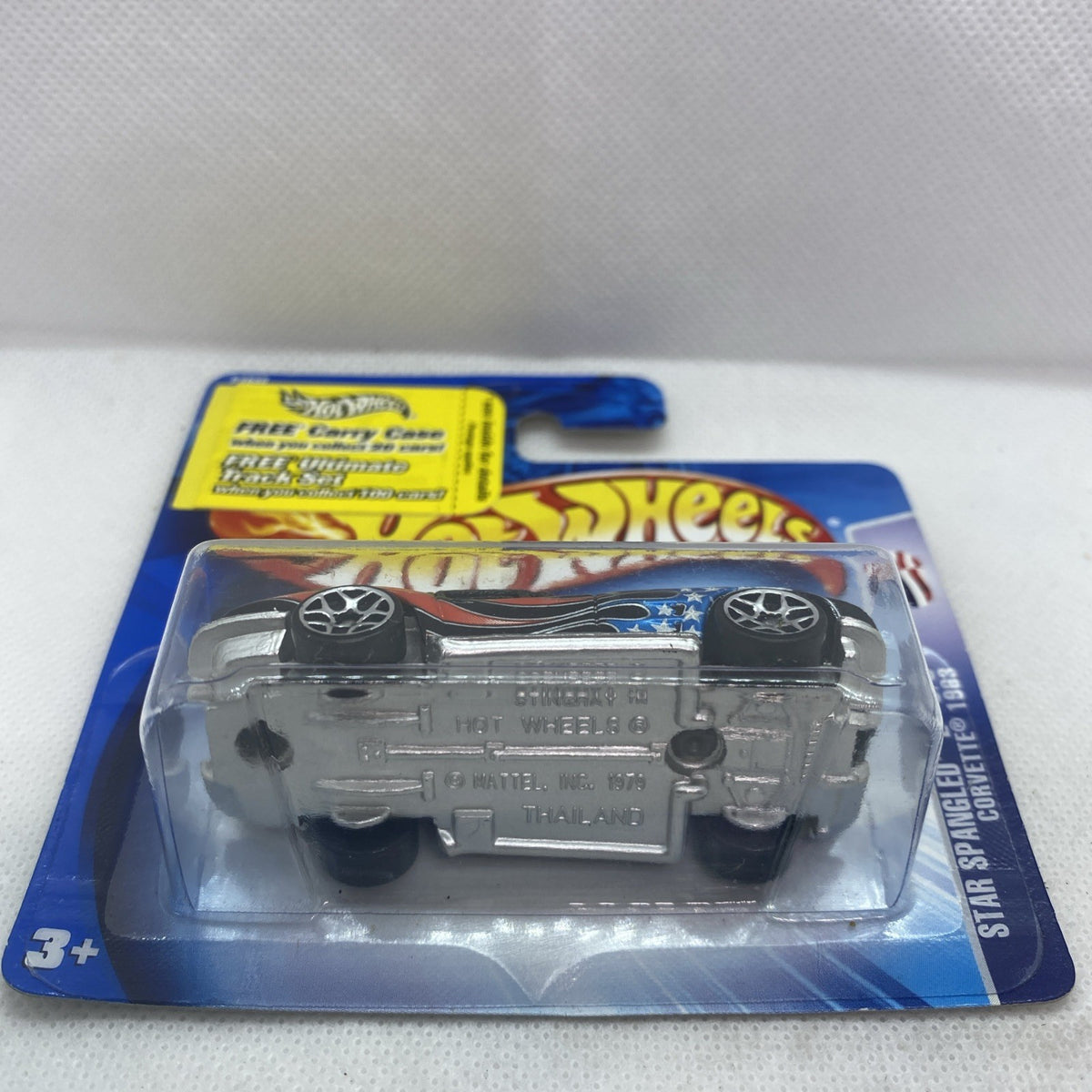 Hot Wheels Corvette die-cast in clear blister on blue card, gray with orange flame graphics