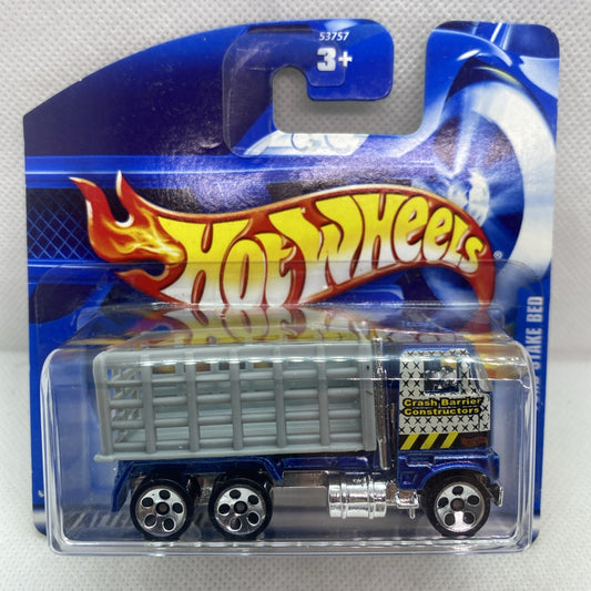 Hot Wheels blue Ford stake bed truck in clear blister, flame logo and wheels visible