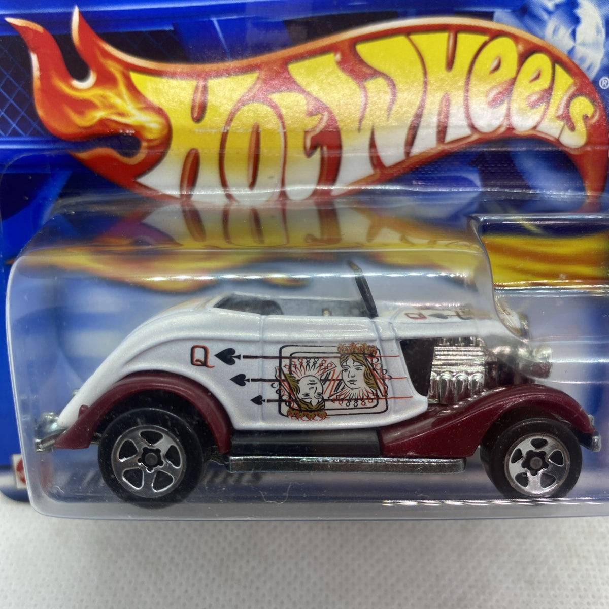Hot Wheels die-cast car close-up in sealed blister, white body with maroon wheels