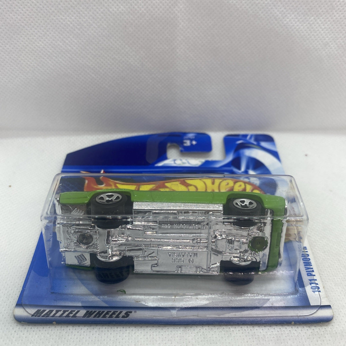 Underside of lime green toy car in blister pack showing chassis details